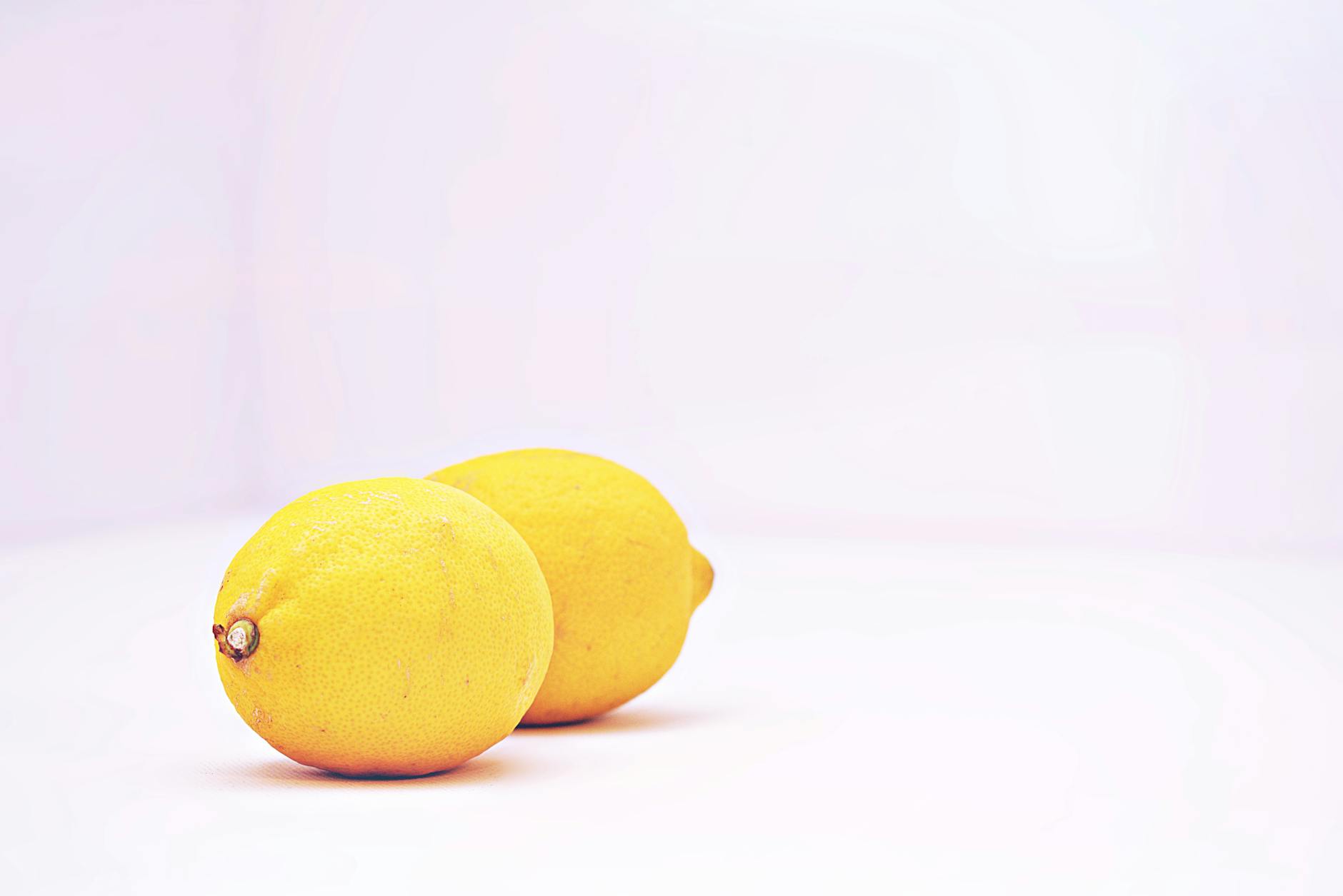 Yellow silicone vibrator surrounded by peeled bananas on yellow background, representing sensuality and self-care