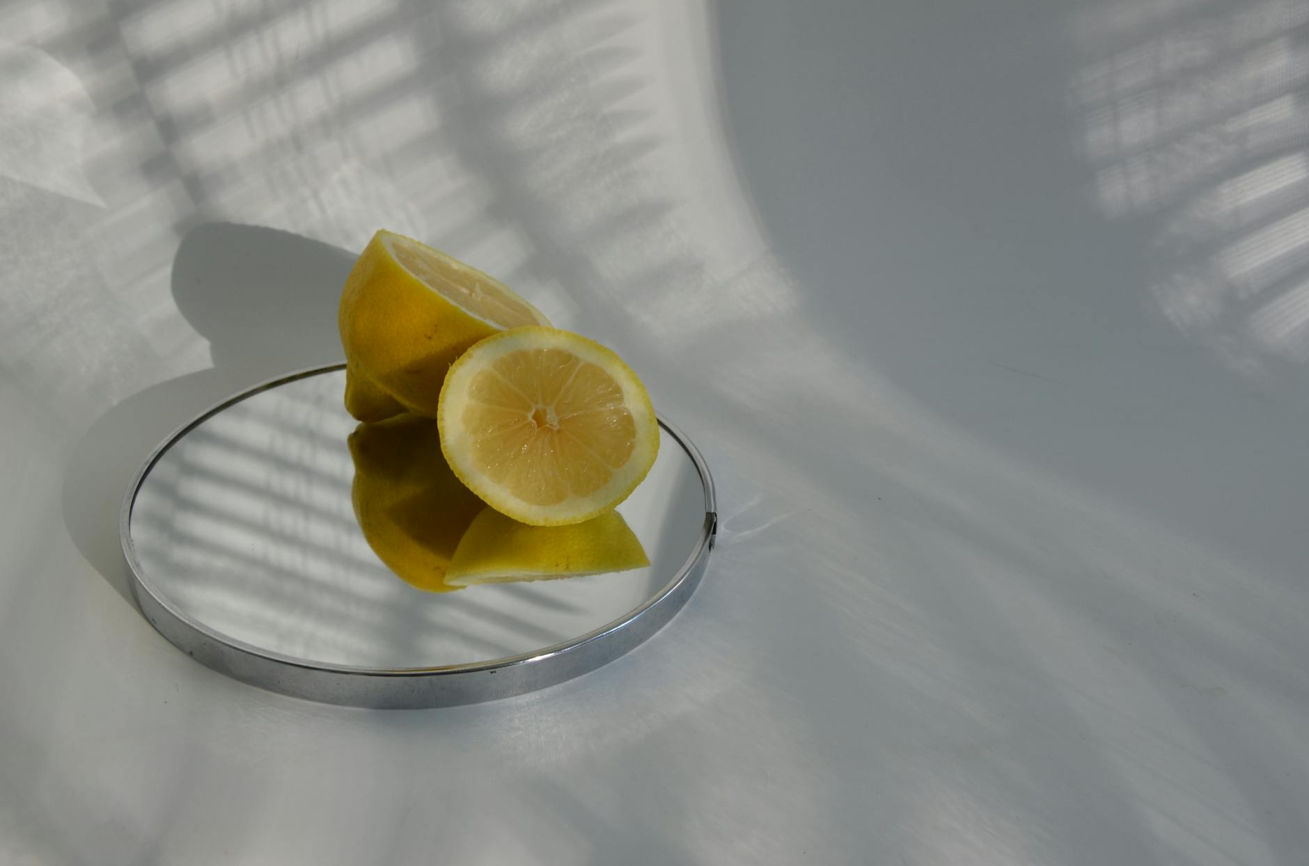 Hands holding a lemon clitoral vibrator against soft fabric, exploring sensation and technique