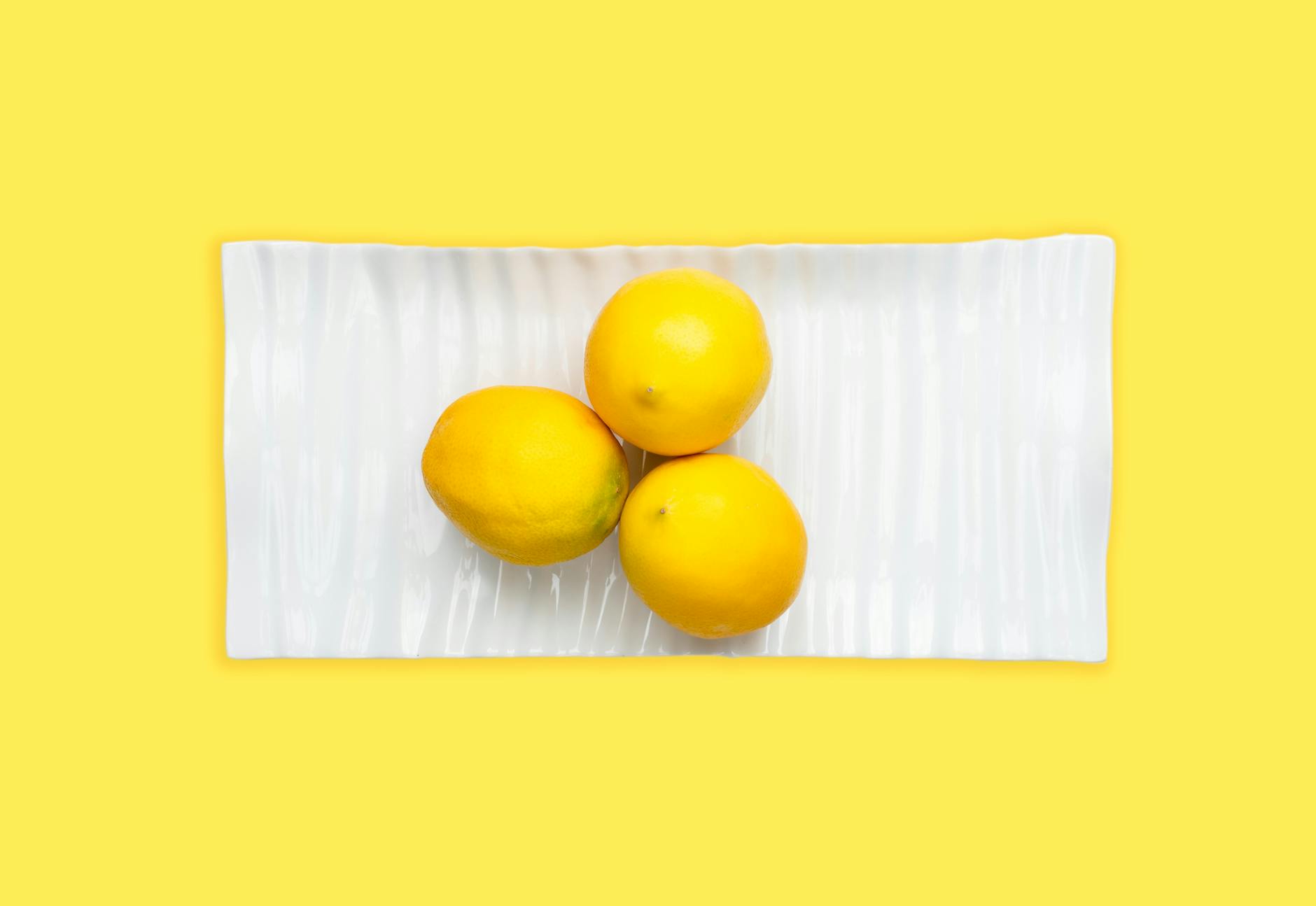 Fresh lemons arranged on a white plate symbolizing clarity and confidence for first-time vibrator users