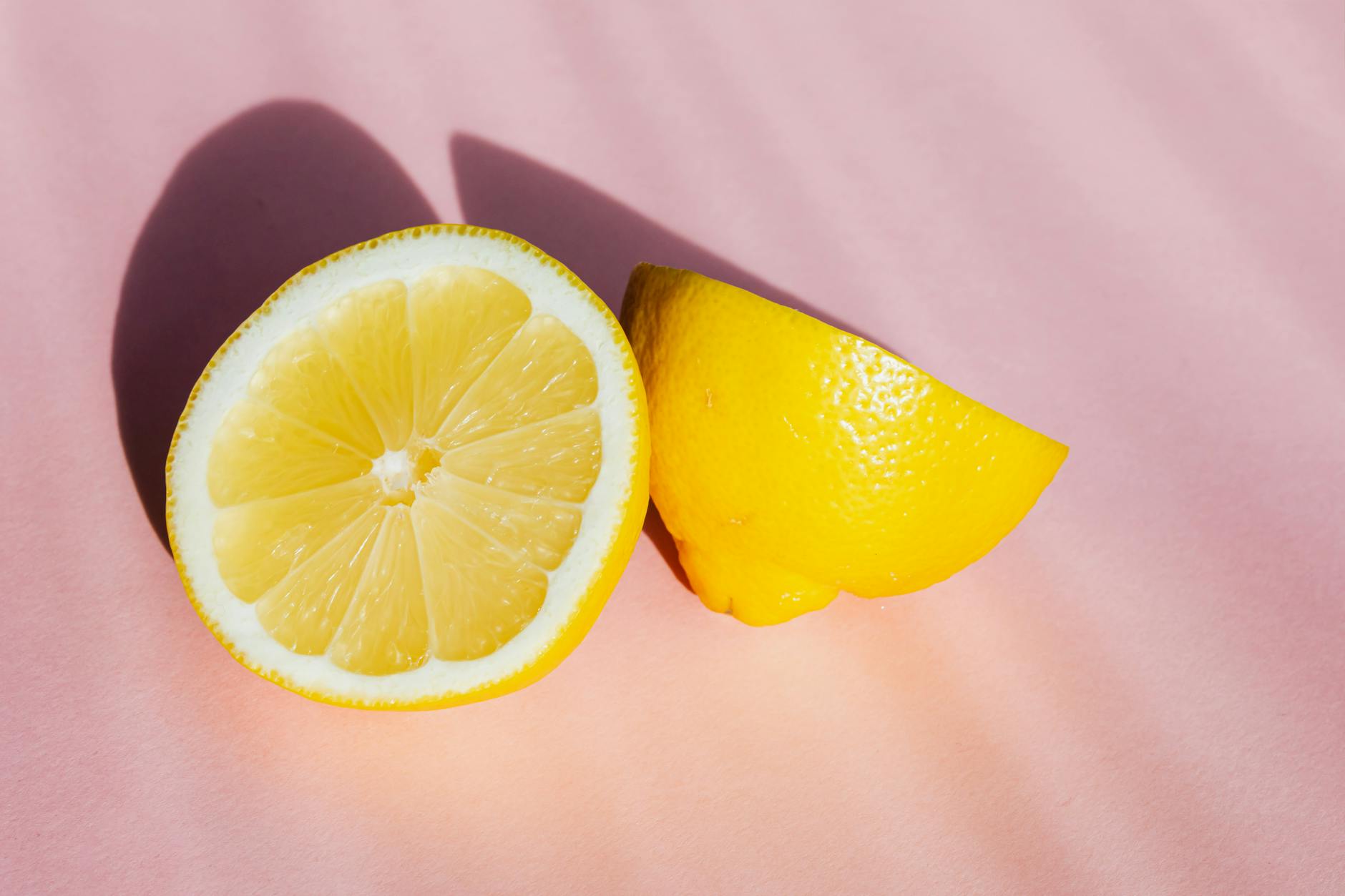 Close-up of a hand holding an orange vibrator against a minimalistic purple backdrop