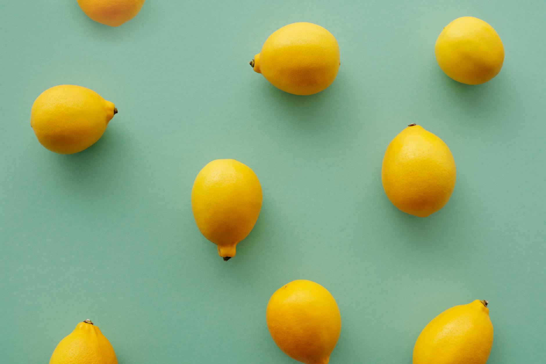 Bright yellow lemons on a pastel green background, symbolizing freshness and the renewal of sensation