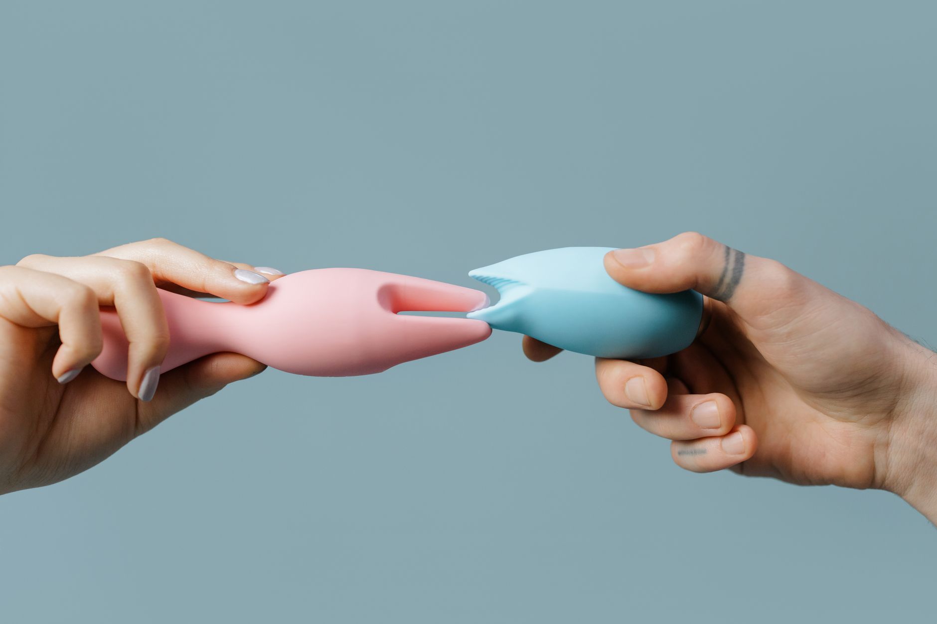 Hand holding a vibrator against a minimalistic purple backdrop, emphasizing sensory exploration