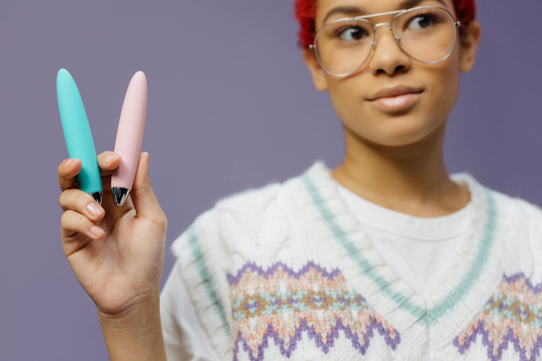 A vibrator held against a skin-tone background, showing product design and texture