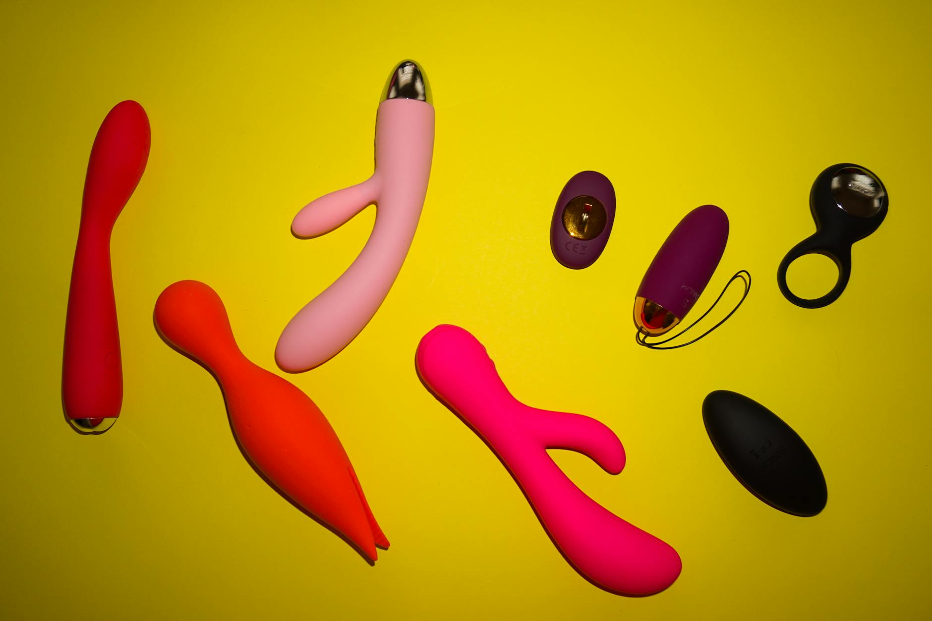 Arrangement vibrant de vibrateurs en silicone sur tissu bleu foncé, mettant en évidence diverses couleurs et formes
